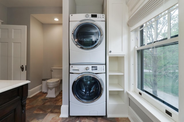 1314 E Washington St, Bloomington, IL 61701 - laundry area featuring baseboards, stacked washer and clothes dryer, and stone finish floor