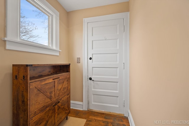 doorway to outside featuring baseboards and dark wood-style floors