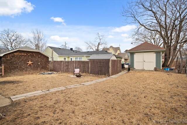 view of yard with a storage shed, fence, and an outdoor structure