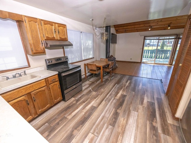 kitchen featuring range hood, a sink, stainless steel range with electric cooktop, wood finished floors, and light countertops