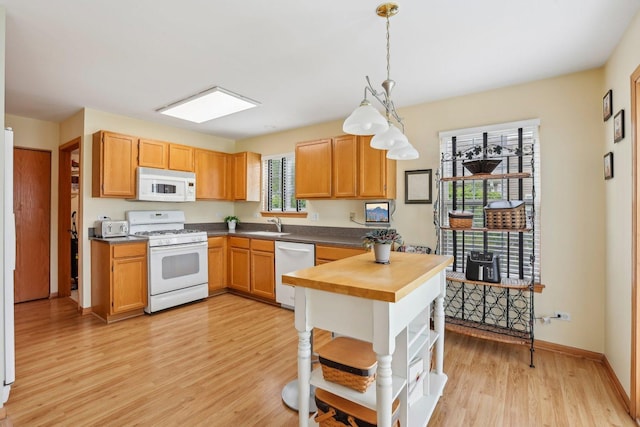 1011 Blackburn Dr, Grayslake, IL 60030 - kitchen featuring white appliances, open shelves, light wood finished floors, hanging light fixtures, and a sink