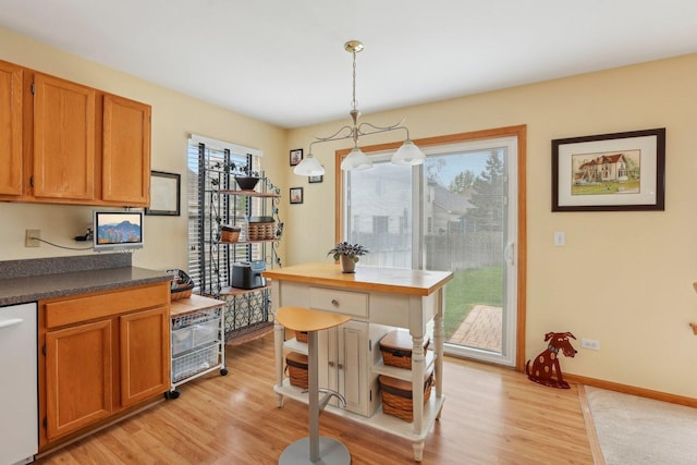 1011 Blackburn Dr, Grayslake, IL 60030 - kitchen featuring light wood finished floors, brown cabinetry, dark countertops, hanging light fixtures, and dishwasher
