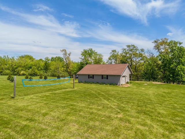 view of grassy yard featuring volleyball court