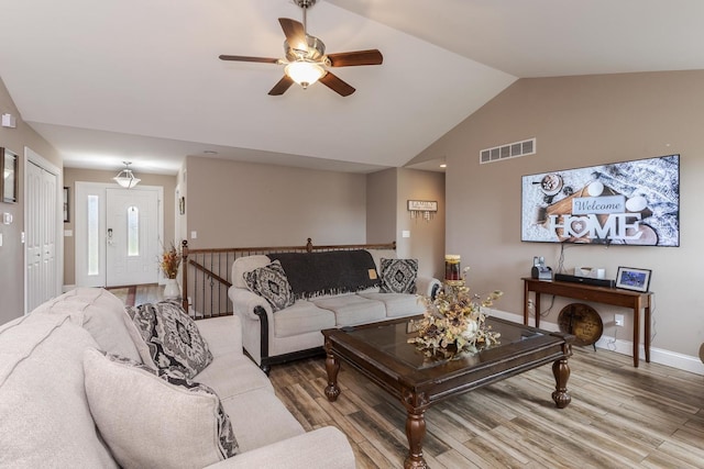 living area with light wood-type flooring, ceiling fan, baseboards, and high vaulted ceiling