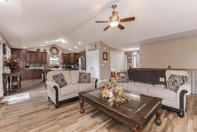 living room with lofted ceiling, ceiling fan, light wood-type flooring, and recessed lighting