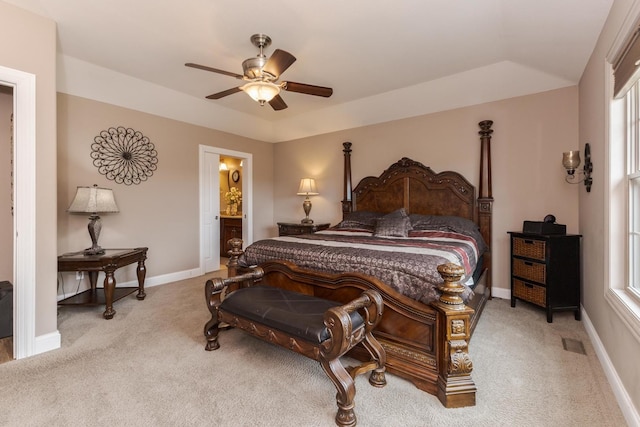 carpeted bedroom featuring baseboards, multiple windows, a ceiling fan, and ensuite bathroom