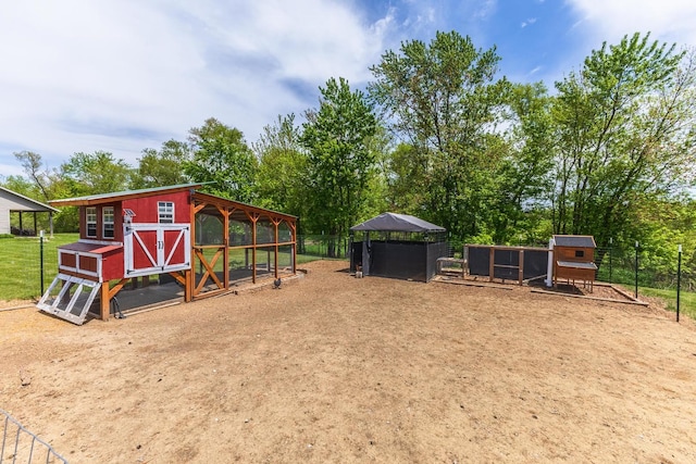 view of play area with exterior structure, an outdoor structure, and view of scattered trees