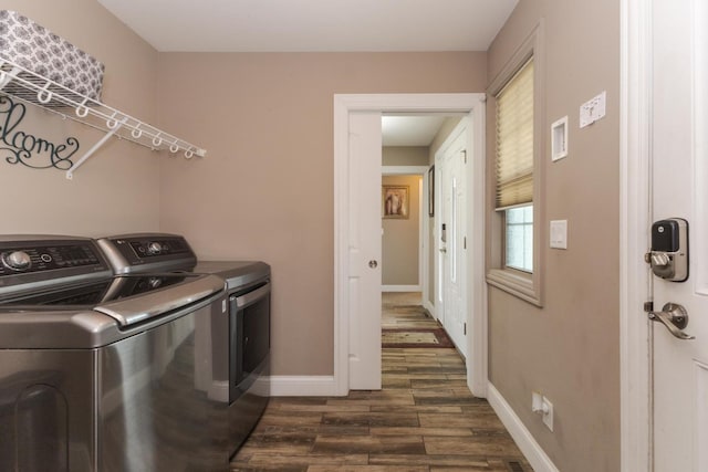 washroom featuring washer and clothes dryer, dark wood-style flooring, and baseboards