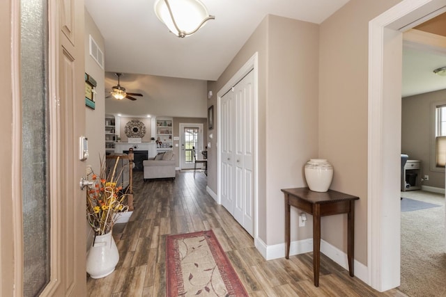 corridor featuring baseboards and wood finished floors