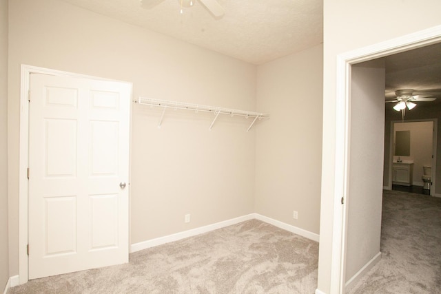 washroom featuring baseboards, a ceiling fan, and carpet