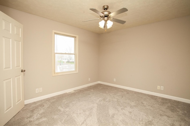 spare room featuring baseboards, ceiling fan, and carpet flooring