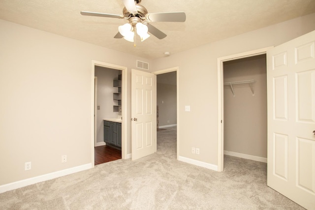 unfurnished bedroom featuring carpet floors, baseboards, a closet, and visible vents