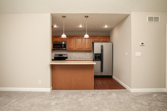 kitchen featuring light countertops, dark carpet, stainless steel appliances, baseboards, and visible vents