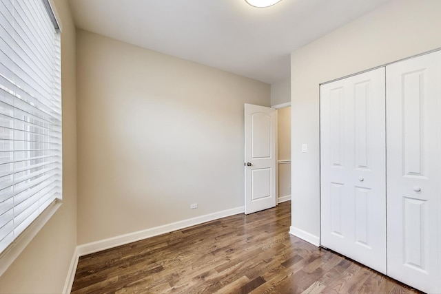 7955 S Paxton Ave, Chicago, IL 60617 - unfurnished bedroom with baseboards, dark wood finished floors, and a closet