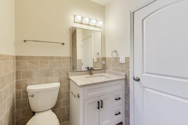 7955 S Paxton Ave, Chicago, IL 60617 - bathroom featuring tile walls, a wainscoted wall, vanity, and toilet