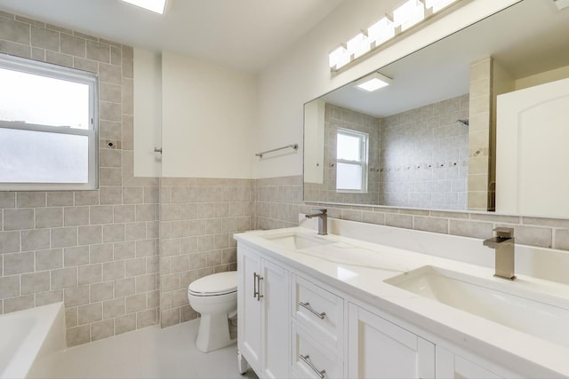 7955 S Paxton Ave, Chicago, IL 60617 - bathroom with a sink, a healthy amount of sunlight, toilet, and tile walls
