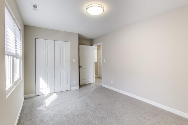7955 S Paxton Ave, Chicago, IL 60617 - unfurnished bedroom with baseboards, multiple windows, visible vents, and light carpet