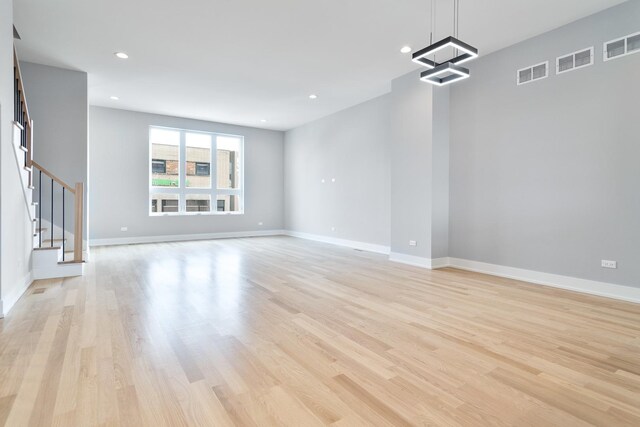 3444 N Central Ave, Chicago, IL 60634 - unfurnished living room featuring light wood finished floors, stairs, baseboards, recessed lighting, and a chandelier