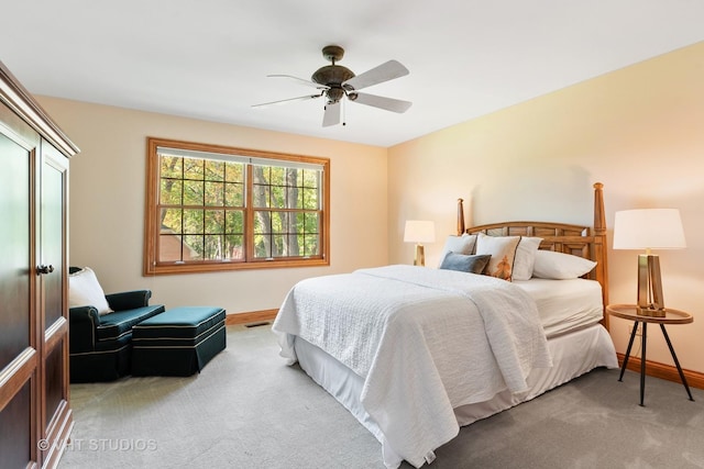 bedroom with light colored carpet, baseboards, and a ceiling fan