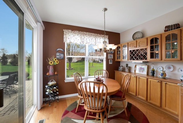 12951 Bull Ridge Dr, Huntley, IL 60142 - dining area with light wood-style floors, a wealth of natural light, visible vents, and a notable chandelier