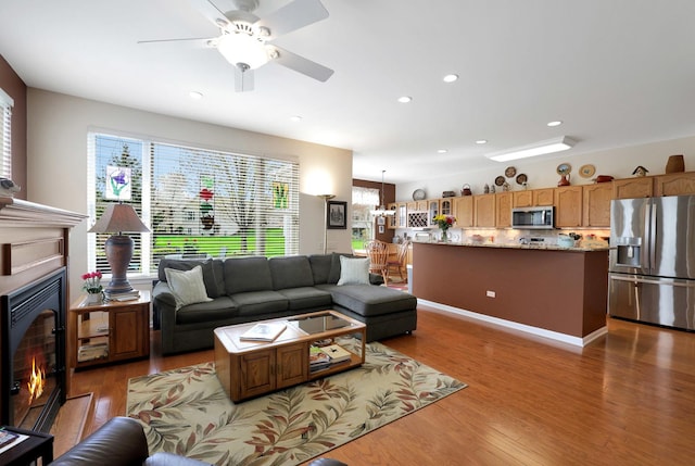 12951 Bull Ridge Dr, Huntley, IL 60142 - living area with a glass covered fireplace, ceiling fan, recessed lighting, and wood finished floors