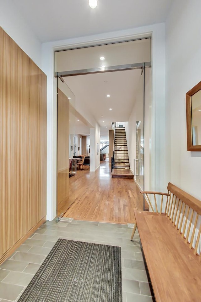 corridor with stairway, recessed lighting, and wood finished floors