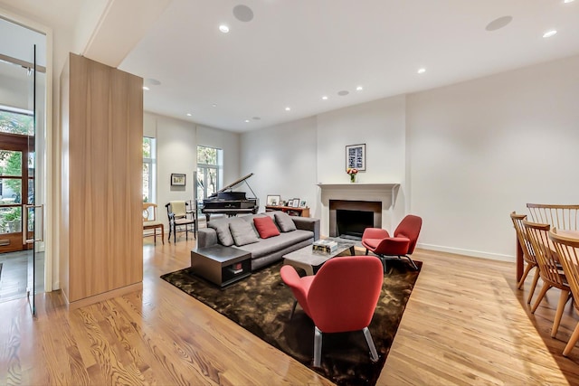 living room with light wood-style floors, recessed lighting, baseboards, and a fireplace