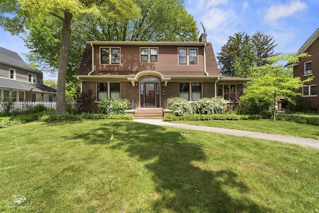 view of front of home featuring a chimney and brick siding