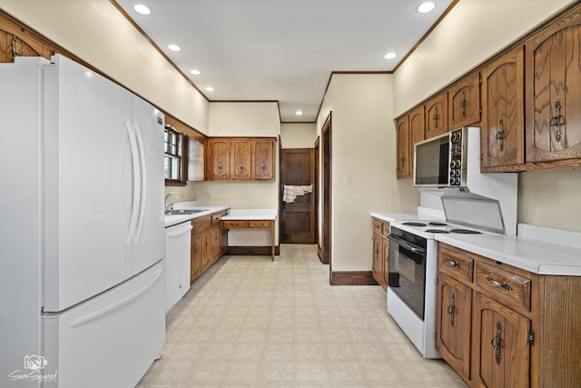 kitchen featuring white appliances, light flooring, light countertops, brown cabinets, and recessed lighting