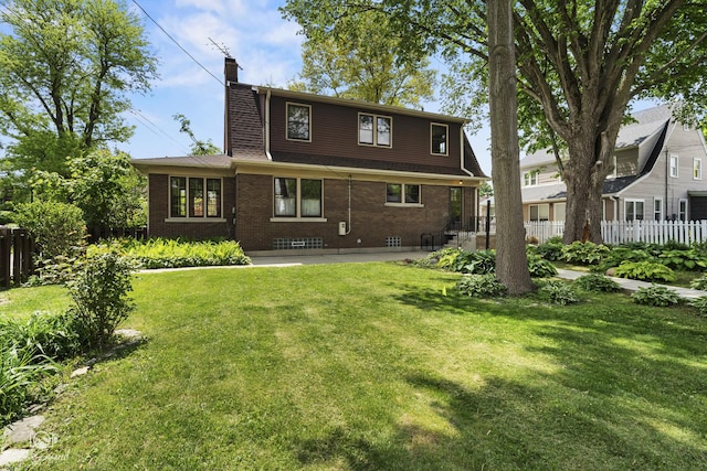 back of property with a chimney, brick siding, and a patio area