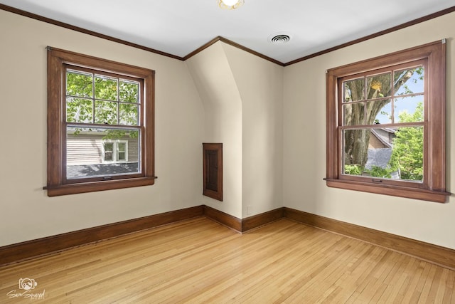 spare room with light wood-style flooring, baseboards, and ornamental molding