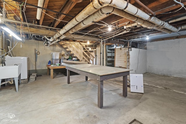 unfinished below grade area with washer / dryer, stairway, and a sink