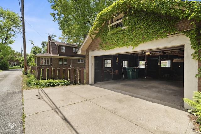 view of front facade featuring brick siding, a garage, driveway, and a chimney