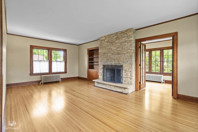 unfurnished living room featuring radiator, crown molding, and baseboards