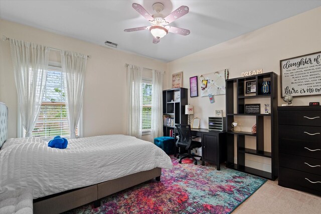carpeted bedroom featuring ceiling fan and visible vents