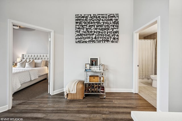 corridor featuring baseboards and wood finished floors