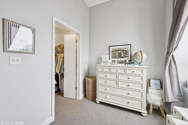 bedroom with carpet, baseboards, and a spacious closet