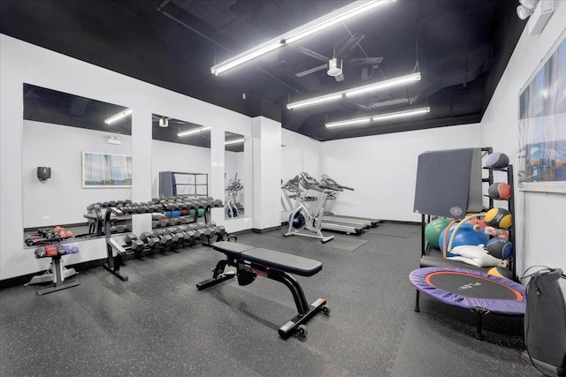 exercise room featuring baseboards and a ceiling fan