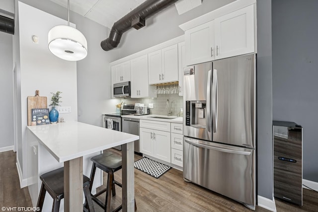 kitchen featuring beverage cooler, appliances with stainless steel finishes, dark wood-style floors, and a sink