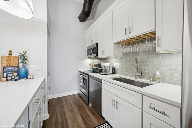 kitchen featuring a sink, white cabinets, backsplash, light countertops, and appliances with stainless steel finishes