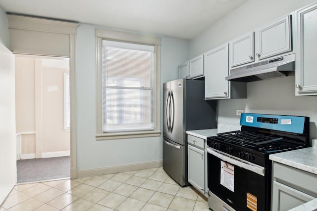 1752 E 72nd Pl, Chicago, IL 60649 - kitchen with range with gas stovetop, under cabinet range hood, baseboards, and light tile patterned flooring