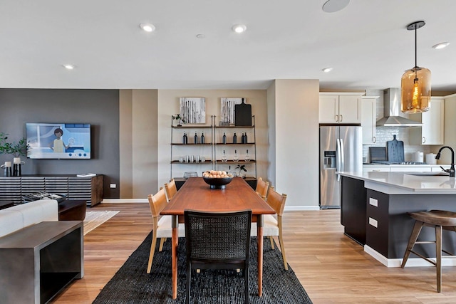 dining room featuring recessed lighting, baseboards, and light wood-type flooring