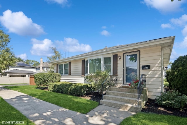 single story home with a front lawn and fence