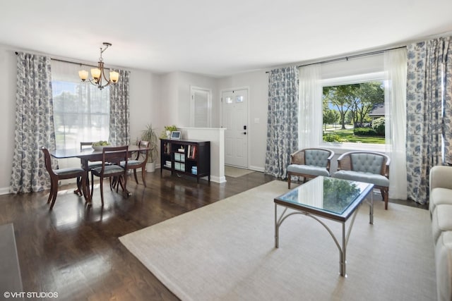 living room with baseboards, dark wood finished floors, and a chandelier