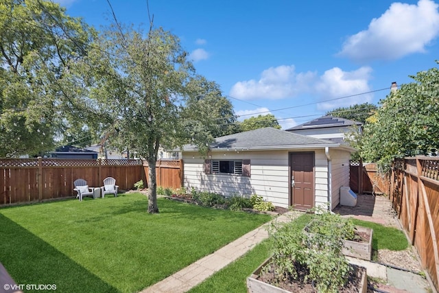 view of yard with a fenced backyard, an outdoor structure, and a vegetable garden