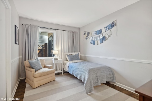 bedroom with baseboards and wood finished floors