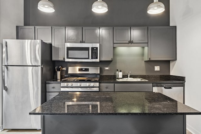 kitchen featuring a sink, appliances with stainless steel finishes, gray cabinetry, and a kitchen island