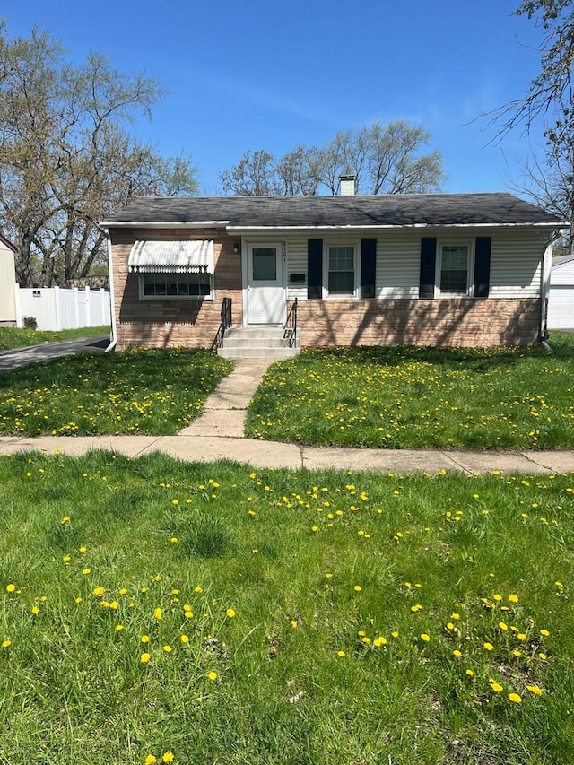 2101 221st St, Sauk Village, IL 60411 - view of front facade featuring fence, a front lawn, and brick siding