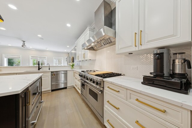 1924 N Wolcott Ave, Chicago, IL 60622 - kitchen with stainless steel appliances, wall chimney range hood, decorative backsplash, a sink, and recessed lighting