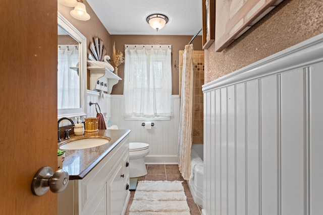 503 E Cedar Ln, Monticello, IL 61856 - bathroom featuring toilet, tile patterned flooring, vanity, a wainscoted wall, and a decorative wall